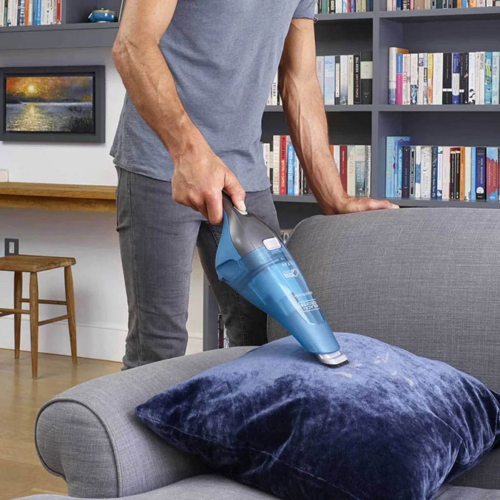 Le Dustbuster aspire un coussin sur un canapé