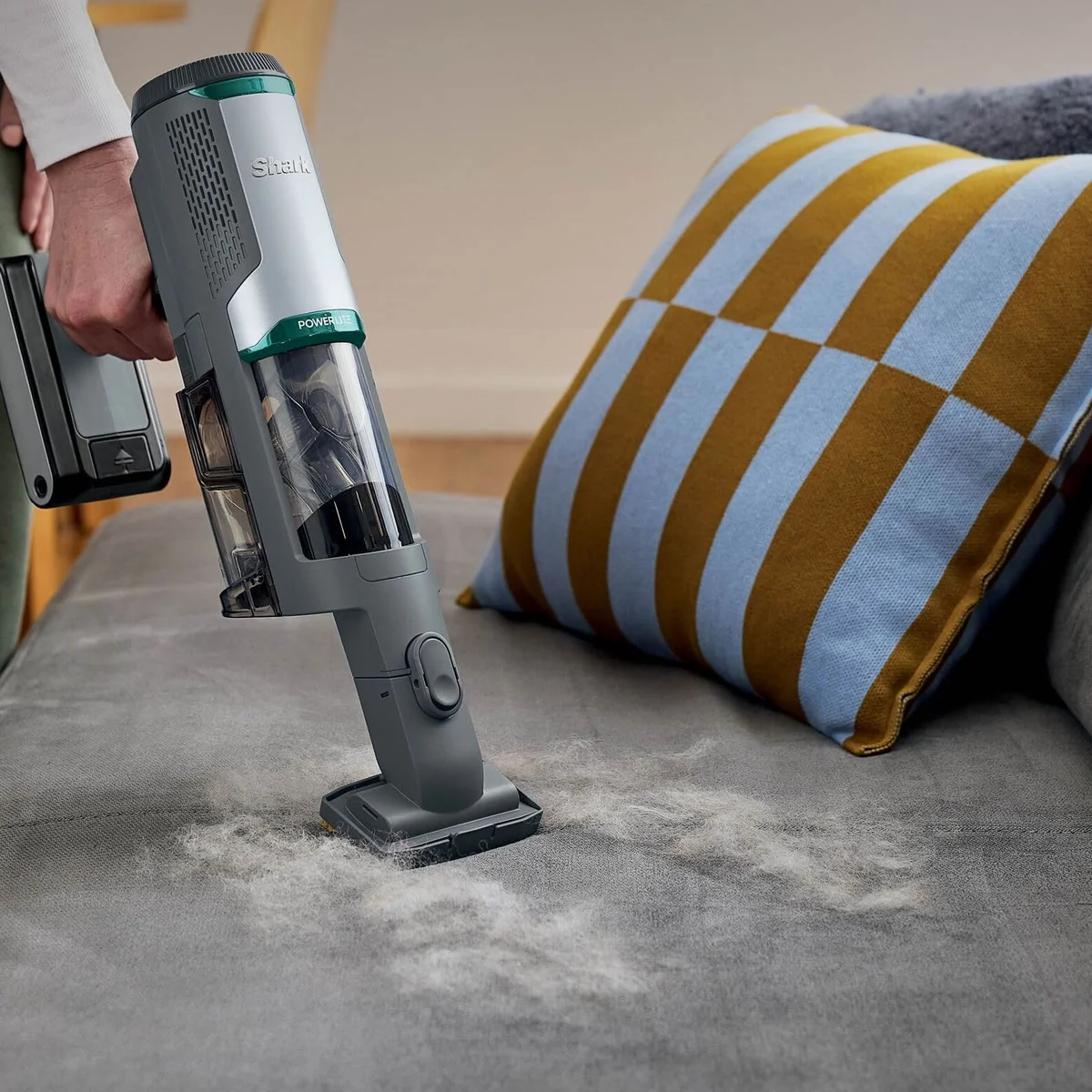 Le Shark PowerLite Clean & Empty en aspirateur à main sur un canapé