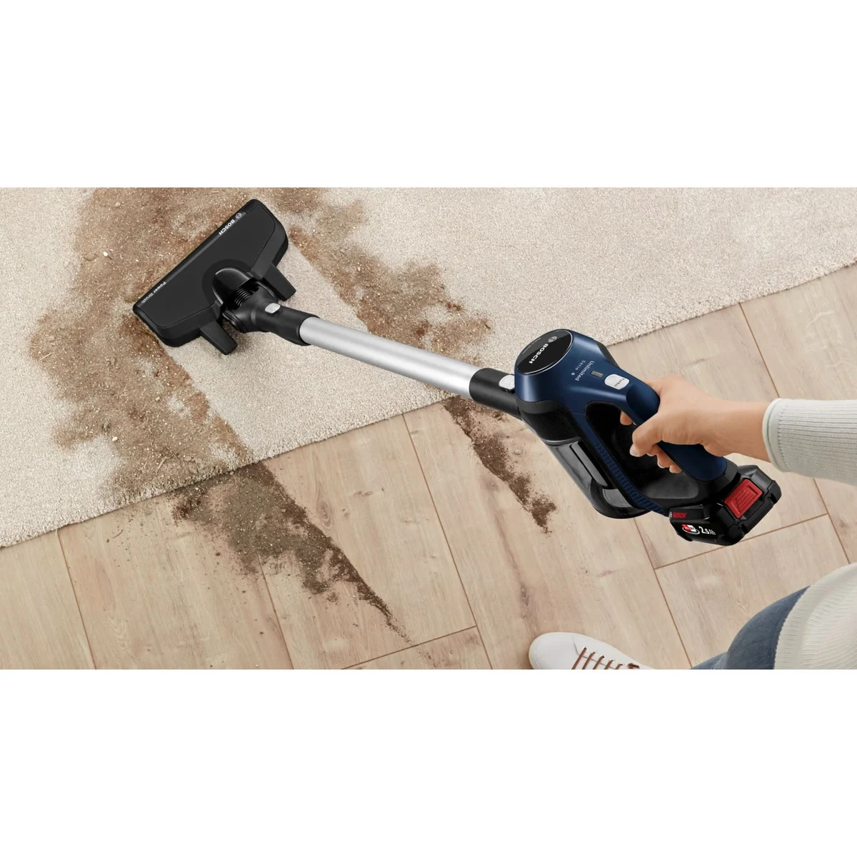 Le Bosch Unlimited 6 aspire de la terre entre un tapis et un parquet